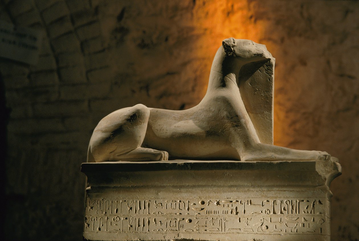 Kalkstenen beeld van de jakhalsgod Anubis geknield op een basis in de vorm van een sarcofaag, 2002 door Kenneth Garrett