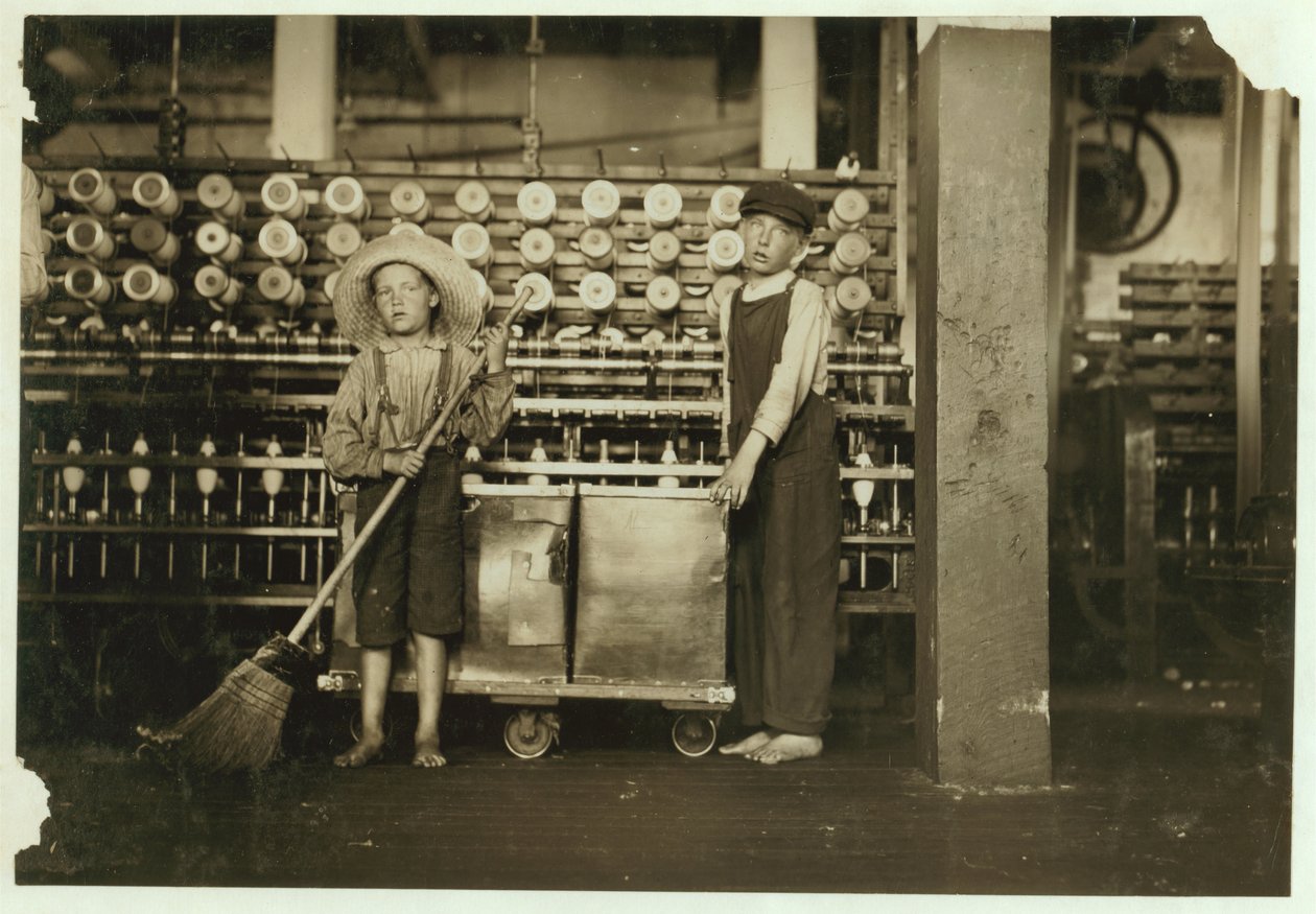 12-jarige doffer Ronald Webb en 7-jarige Frank Robinson, zoon van cardroom baas, die veegt en doft bij Roanoke Cotton Mills, Virginia, 1911 door Lewis Wickes Hine
