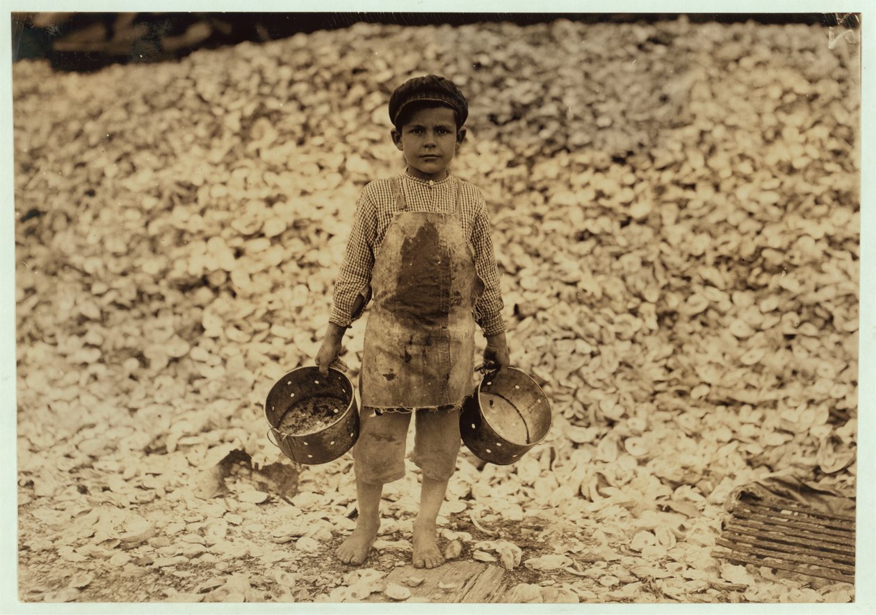 De 5-jarige migrant garnalenplukker Manuel voor een stapel oesterschelpen, werkend voor een tweede jaar bij Dunbar, Lopez, Dukate Company, Biloxi, Mississippi, 1911 door Lewis Wickes Hine