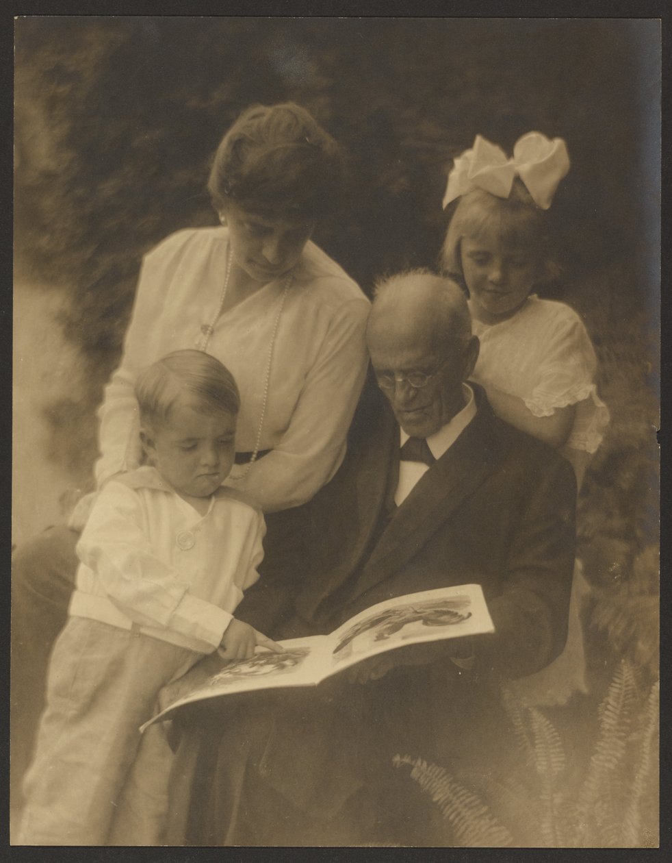 [Familiefoto met prentenboek] door Louis Fleckenstein