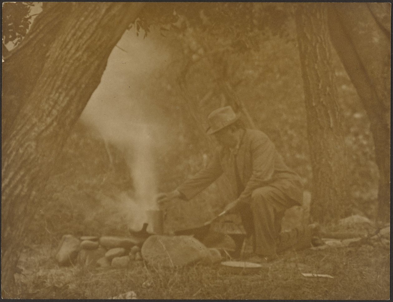 [Man die boven een kampvuur in het bos kookt] door Louis Fleckenstein