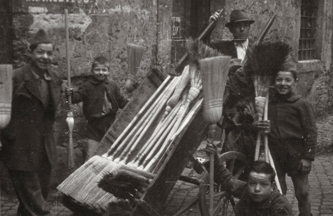 Brooms on street vendors door Luigi Leoni