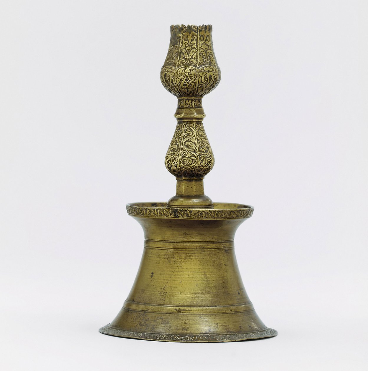 Een Ottomaanse koperen kandelaar, de hals met gegraveerde arabeske decoratie die uitloopt in de vorm van een tulp door Ottoman School