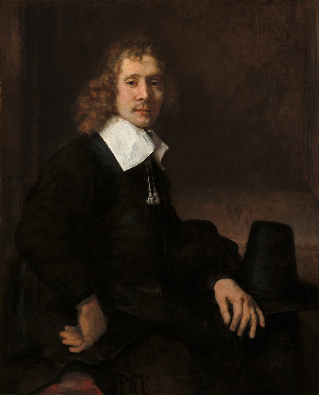 Een jonge man zittend aan een tafel mogelijk Govaert Flinck door Rembrandt van Rijn