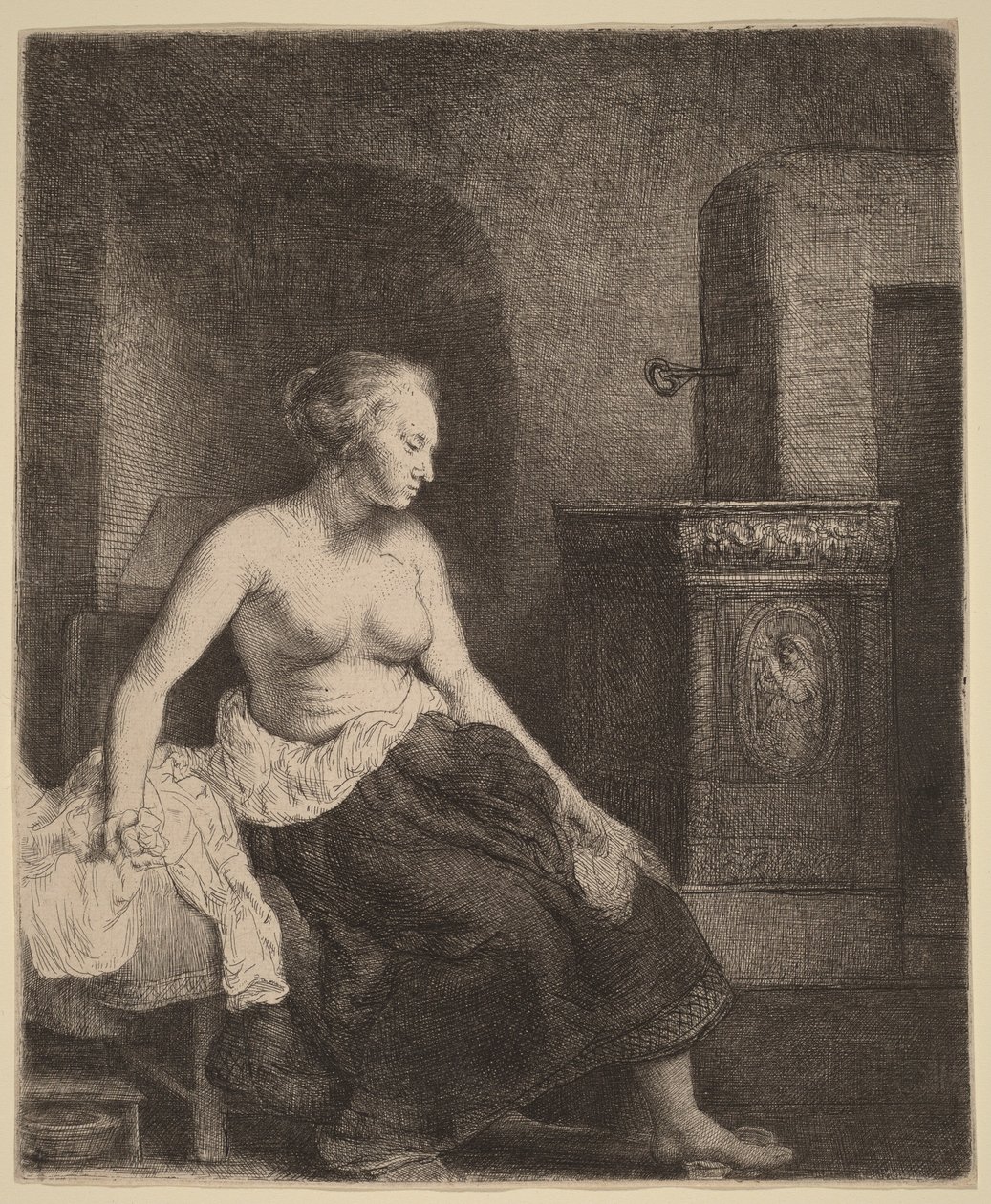 Vrouw, half aangekleed, zittend naast een kachel door Rembrandt van Rijn