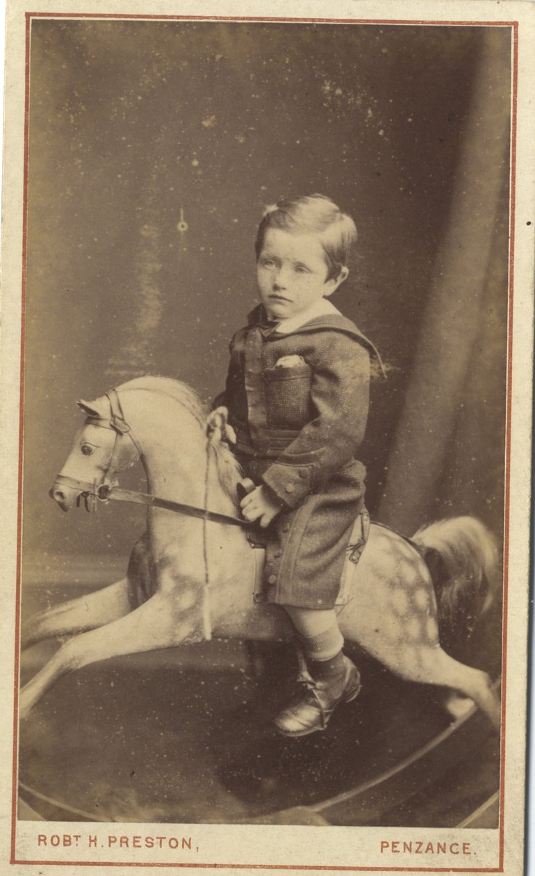 Jonge jongen zittend op een schommelpaard door Robert H. Preston