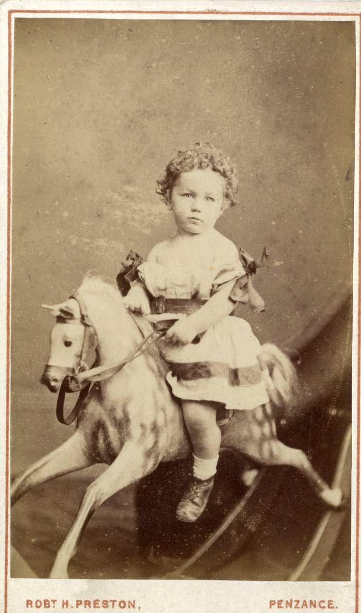 Jong meisje zittend op een schommelpaard door Robert H. Preston