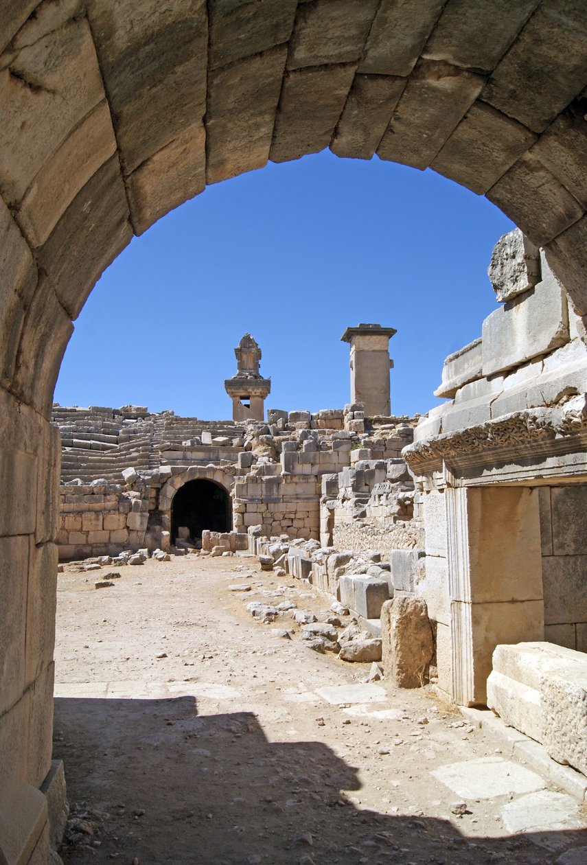 Uitzicht door de gewelfde ingang van het Xanthos-theater naar de orkestbak, met zuil en Harpy-tombe, Xanthos, Turkije (foto) door Roman