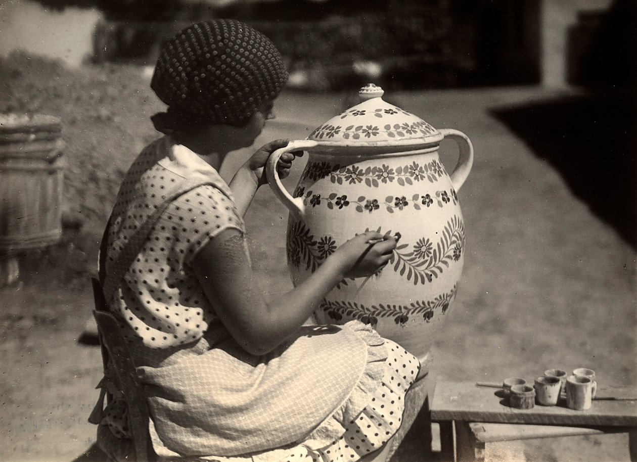 Een Hongaarse dame geportretteerd terwijl ze een amphora schildert met bloemmotieven; naast haar, op een kleine bank, de kwasten en de glazen met de kleuren door Rudolf Balogh