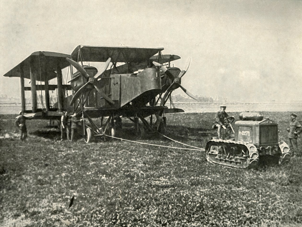 Een kleine motortractor die een enorme R.A.F. bommenwerper op zijn plaats zet..., 1919 door Unbekannt