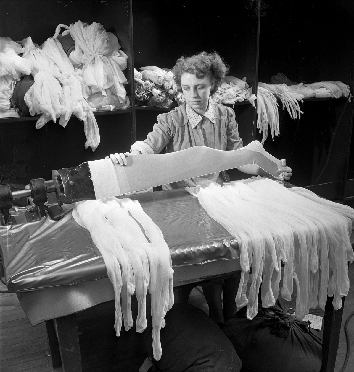Een vrouwelijke arbeider inspecteert wollen panty
