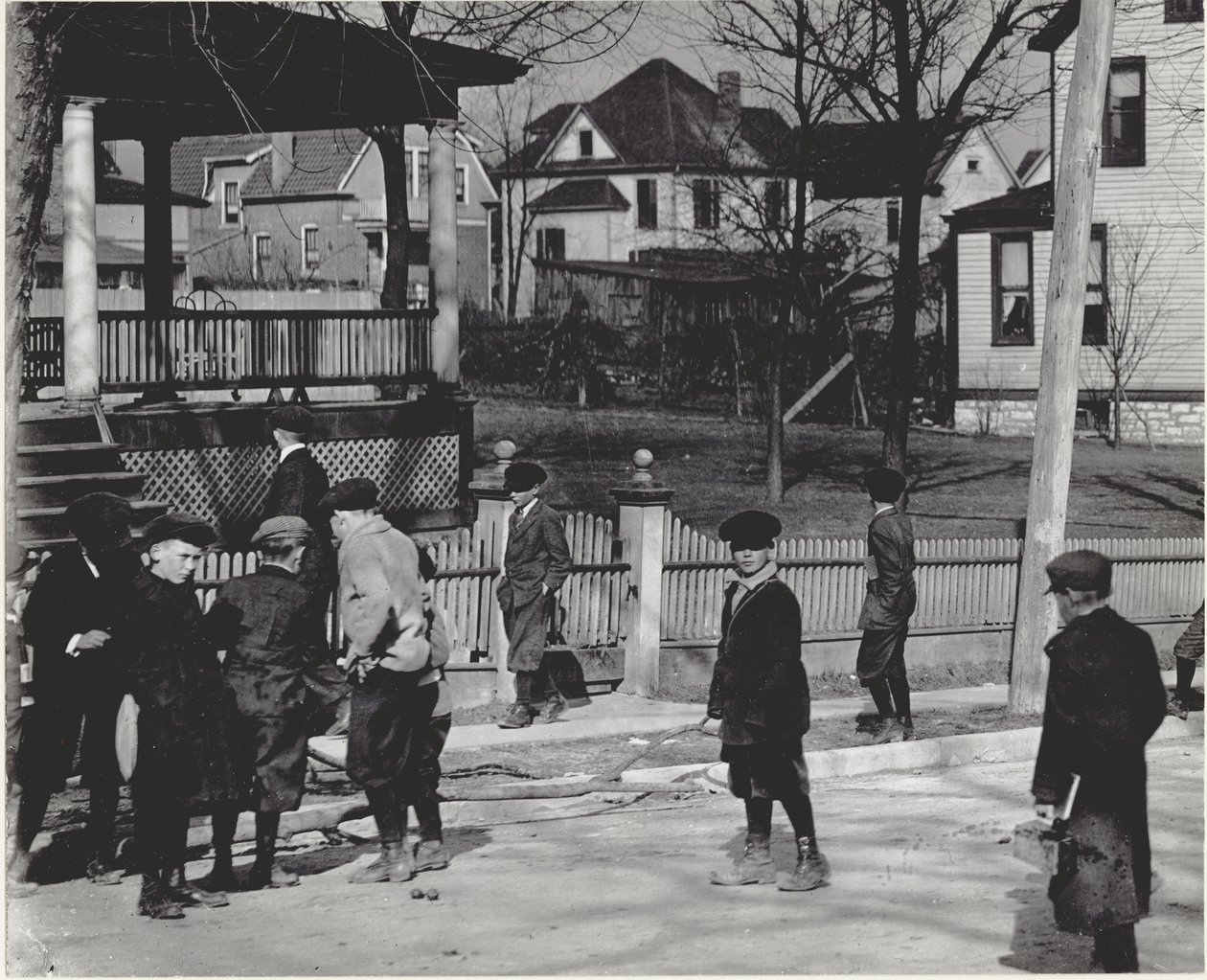 Een groep jongens in winterjassen die op een onbekende straat staan, voor of na een schooldag. door Unbekannt