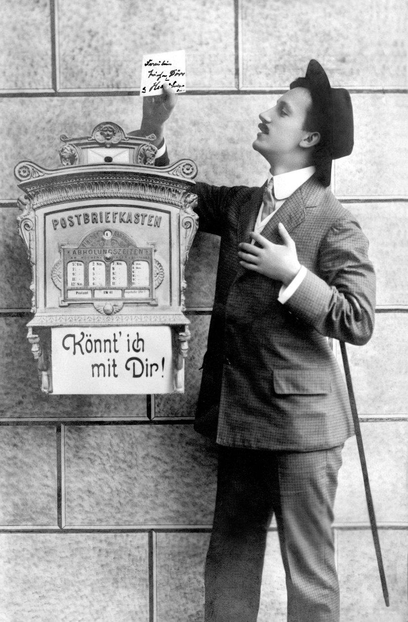 Een elegante man in een pak, hoed en stok, plaatst een brief in een brievenbus. Duitsland rond 1920 door Unbekannt