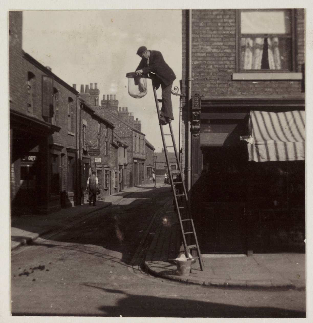 Man die een gaslantaarn schoonmaakt, ca. 1905 door Unbekannt
