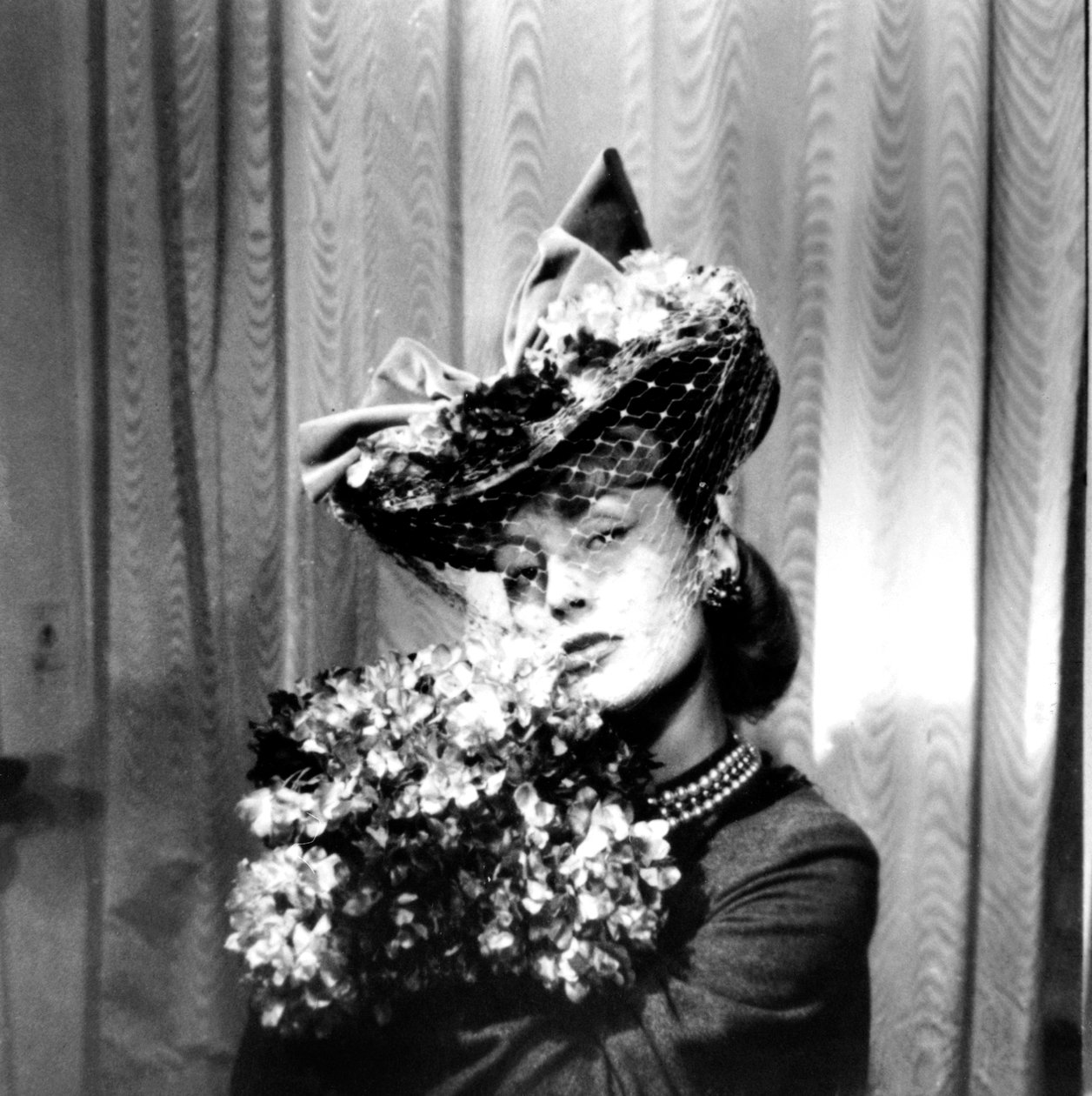 Vrouw met een hoed met een sluier, die een boeket bloemen vasthoudt, Parijs, 1943 door Unbekannt