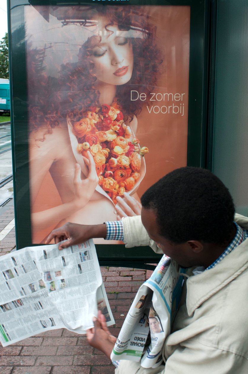 Man leest een krant bij een tramhalte in Brussel, België door Unbekannt Unbekannt