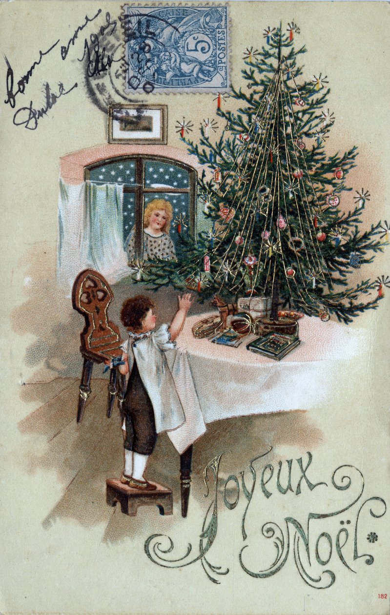 Kerstkaart: een kind voor een kerstboom poseert op een tafel, geobserveerd door een engel in het raam door Unbekannt