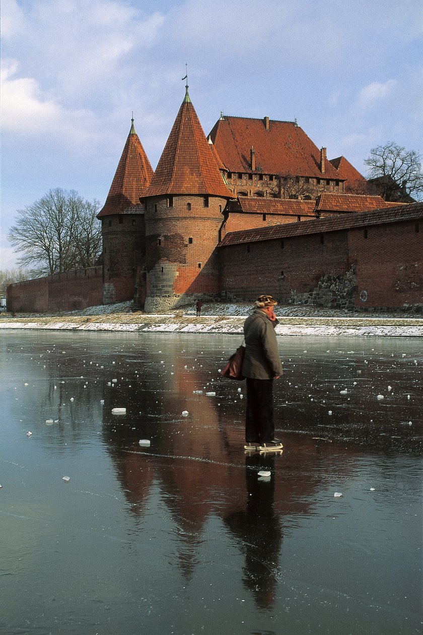 Zijaanzicht van een man die op een bevroren rivier staat voor een kasteel, Nogat Rivier, Malbork Kasteel, Malbork, Pomorskie Provincie, Polen door Benjamin Baud