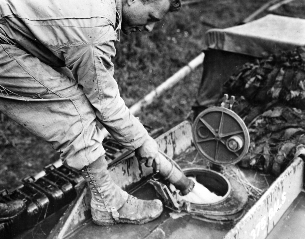 Tweede Wereldoorlog (1939-1945): Normandië (Frankrijk) zomer 1944: Bij een gasopslagstation tankt een soldaat van een Amerikaanse transporteenheid brandstof in de tank van een GMC-tankwagen door Unbekannt
