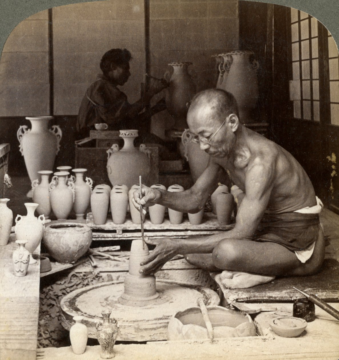 Een pottenbakker en zijn wiel, die een vaas van Awata-porselein vormen, Kinkosan-werken, Kyoto, Japan, 1904 door Underwood and Underwood