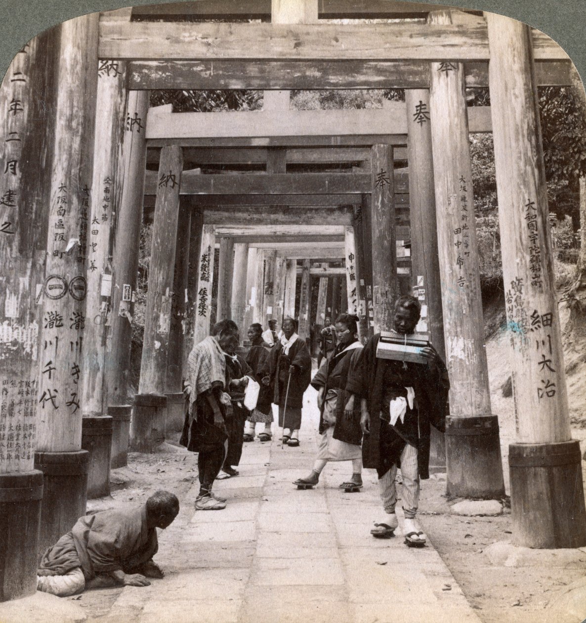 Komen en gaan onder lange rijen heilige torii, Shinto-tempel van Inari, Kyoto, Japan, 1904 door Underwood and Underwood