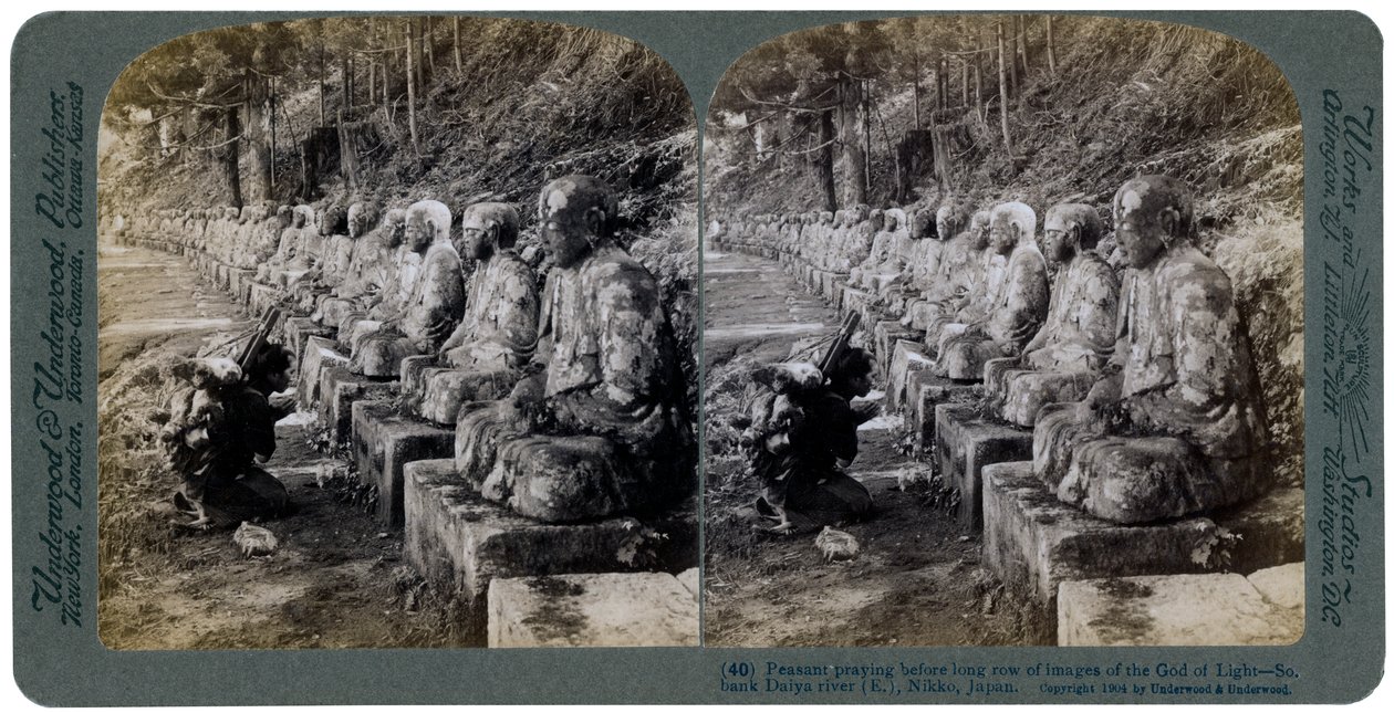 Boer die bidt voor een rij beelden van de God van het Licht, Daiya rivier, Nikko, Japan, 1904 door Underwood and Underwood