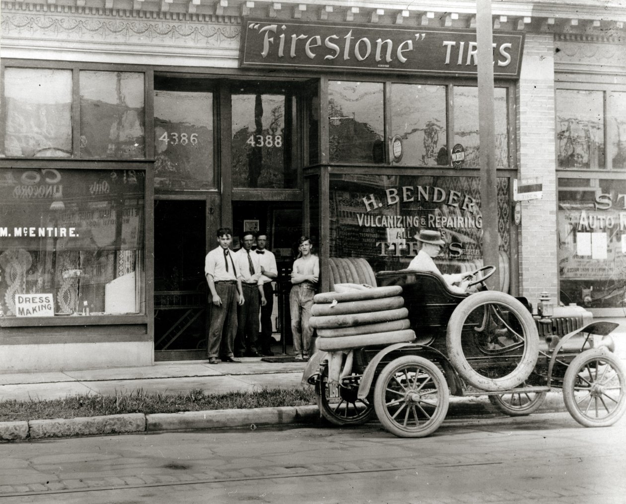 Mannen en vrachtwagen voor autoreparatie verzameld buiten de H. Bender Firestone Tire dealership op 4388 Olive Street door Unknown