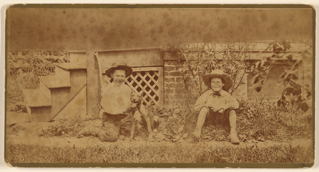 [Twee jongens zitten op de grond met een hond]. door Unknown artist