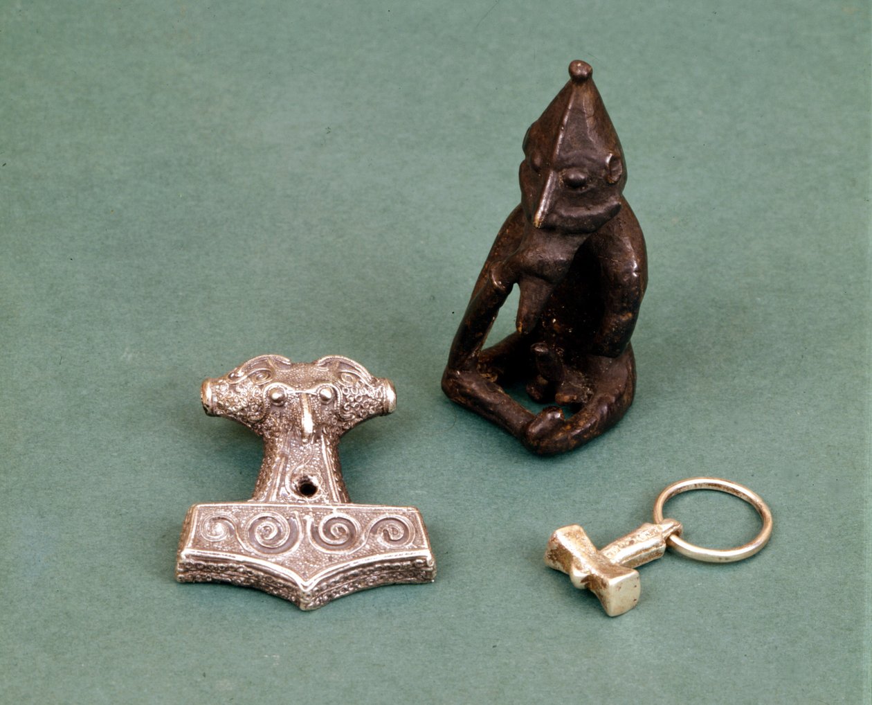 Amuletten van Vikinggoden: op de voorgrond twee kleine zilveren hamers die de god Thor symboliseren. Het beeldje stelt Freyr voor, god van de vruchtbaarheid. Historisch Museum van Stockholm, Zweden. door Viking Viking