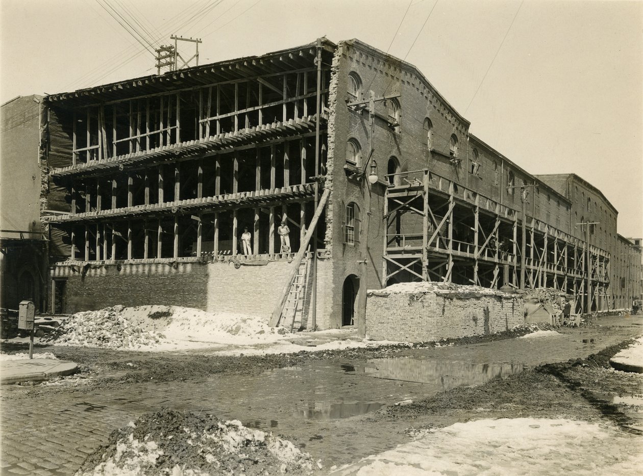 Bouwplaats, twee mannen staan in de open zijde van een magazijngebouw; Robbins und Ripley Engineers and Contractors, 23 maart 1916 door William Davis Hassler