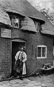 Een man die een pijp rookt buiten een winkel, Worcestershire, ca. 1922 door A. W. Cutler