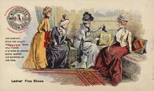 Dames zitten op bank en bewonderen laarzen