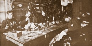 In de hut tijdens de midwinter, de mannen bezig met het naaien van bont voor kleding voor gebruik in de lente, uitgegeven Londen 1907 (zwart-wit foto) door Anthony Fiala