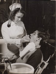 [Mondhygiënist inspecteert de mond van een patiënt]. door Arnold Eagle