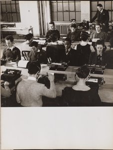 [Mensen zitten voor typemachines met koptelefoons op].