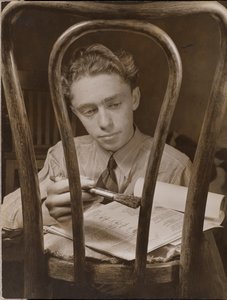 [Jonge man schildert de rugleuning van een houten stoel].