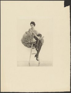 [Vrouw in kannenkostuum zittend op kruk]. door Arthur F. Kales