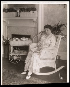 Mevrouw Howard zittend met een boek in een schommelstoel in haar huis op 200, 5th Avenue, New York, 1915-6