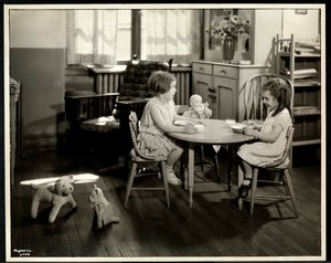Twee blinde meisjes die eten aan een kleine tafel met een pop bij de New York Association for the Blind, 111 East 59th Street, New York, 1933 (zilveren gelatin afdruk)