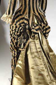 Avondjurk, ca. 1884 (achteraanzicht van detail van de bustle). Zijde satijn en gesneden fluweel, kant, zijden kwastjes en franjes. Charles Frederick Worth, Frankrijk.