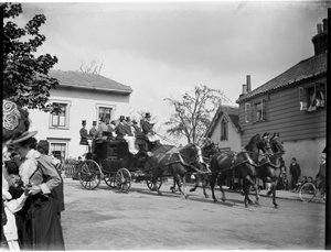Een door paarden getrokken koets die langs een groep huisjes rijdt, Greater London Authority