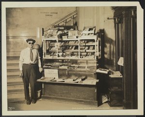 Blinde krantenverkoper, John Martie, bij zijn stand aan het zuideinde van het gemeentelijk gebouw, New York door Company Byron