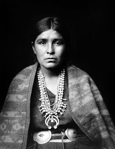 Navajo-vrouw met zilveren squash-bloem ketting, concho riem, deken over schouders, c. 1904