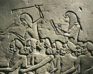 Een groep negroid gevangenen omringd door bewakers gewapend met knuppels terwijl een schrijver een rapport opstelt. Reliëf uit het graf van Horemheb in Saqqara, detail