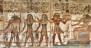 Egyptische oudheid: eerste hof, detail van geschilderde reliëfs die de farao voorstellen die offers brengt aan de goden Horus en Khnoum. Dodentempel van Ramses III (1187-1156 v.Chr.). Luxor, Medinet Habou, Egypte