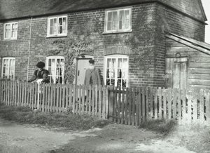 Een landelijk tafereel in de omgeving van Wandsworth met een ouder echtpaar in de tuin van een huis in cottage-stijl, Londen, 1895 door English Photographer