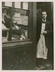 Een winkelier die in de deuropening van zijn winkel staat door English Photographer
