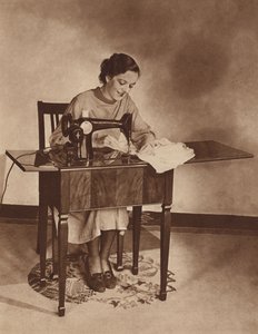 Huisvrouw aan het werk op de naaimachine, midden jaren 1930 (zwart-wit foto) door English Photographer