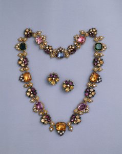 Een fijne Regency gouden en met juwelen versierde ketting met kussen geslepen topaas, amethisten, roze toermalijnen, smaragden, saffieren en peridots, met een paar bloemvormige oorbellen, c.1810 door English School