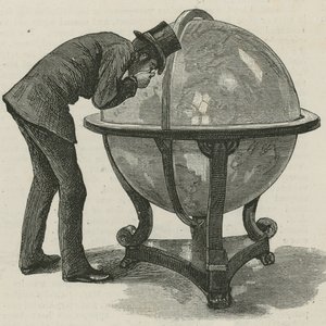 Een man van Lloyds die een globe bestudeert